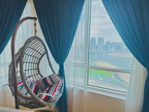 a wicker chair in a room with a window at lagoon view-Entire apartment in Sharjah