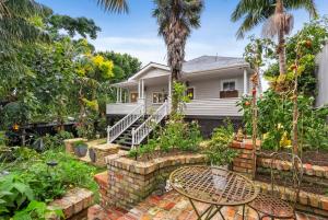 ein Haus mit einem Garten und einer Terrasse in der Unterkunft Eden Park Bed And Breakfast Inn in Auckland