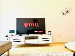 a television sitting on a white dresser in a living room at lagoon view-Entire apartment in Sharjah