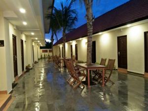 a patio with tables and chairs in a building at Familytel Bali in Jimbaran