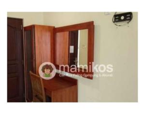 a room with a mirror and a wooden desk at Familytel Bali in Jimbaran