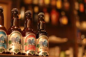 une rangée de bouteilles de bière assise sur une étagère dans l'établissement Kamikochi Hotel, à Matsumoto