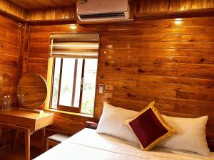 a bedroom with a bed and a desk and a window at Tam Coc Rocky Hotel in Ninh Binh