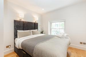 a bedroom with a large bed with a large headboard at Central Fitzrovia - 1BR - CityApartmentStay in London