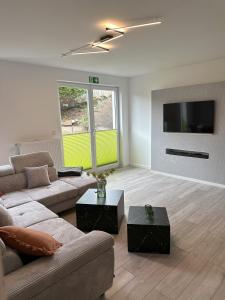 ein Wohnzimmer mit Couch und Flachbildfernseher in der Unterkunft VennOase in Monschau