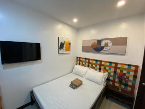 a small room with a couch and a flat screen tv at Ati Lodge Boracay in Boracay