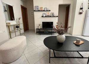 a living room with a table and a vase on a table at NIKI APARTMENT 80 m2 IN GRIBOVO in Nafpaktos