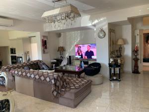 sala de estar con sofá y TV de pantalla plana en Villa Calma en Lazaréton