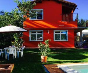 een rood huis met een tafel en een paraplu bij Ferienhaus mit Privatpool für 17 Personen ca 230 qm in Panicagliora, Toskana Provinz Pistoia in Serra Pistoiese