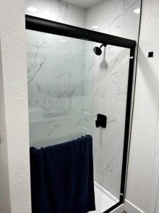 d'une douche avec une porte en verre et une serviette bleue. dans l'établissement Cozy Modern Cabin, à Big Bear City