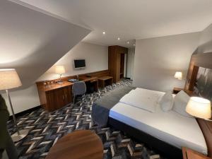 ラシュテーデにあるResidenz Hotel Zum Zollhausのベッドとデスクが備わるホテルルームです。