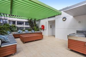 eine Terrasse mit Sofas und einer grünen Decke in der Unterkunft Stellar Location With Parking Pool & Gym Access in Brisbane
