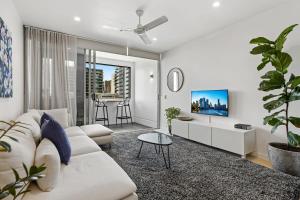 ein Wohnzimmer mit einem weißen Sofa und einem Tisch in der Unterkunft Stellar Location With Parking Pool & Gym Access in Brisbane