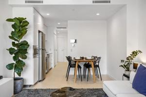 a kitchen and dining room with a table and chairs at Stellar Location With Parking Pool & Gym Access in Brisbane