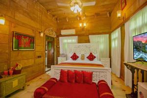 a bedroom with a bed with red pillows at Amritara Manak Haveli, Jodhpur in Jodhpur