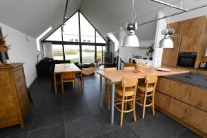 cocina y comedor con mesas y sillas de madera en Meadows, Scherpbierseweg 32, Groede, en Cadzand