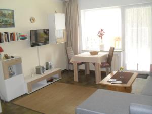 sala de estar con mesa, mesa y sillas en Haus Rosi, en Friedrichskoog-Spitz