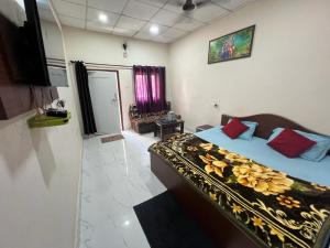 1 dormitorio con 1 cama con sábanas azules y almohadas rojas en Samarth home`stay, en Pachmarhī