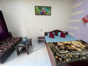 Habitación con 2 camas y mesa. en Samarth home`stay, en Pachmarhī