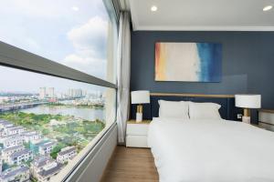 a bedroom with a large bed and a large window at Vinhome Central Park Apartment in Ho Chi Minh City