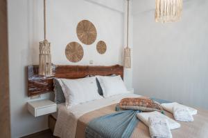a bedroom with a bed with a wooden headboard at Epithea Suites Kythnos 4 με ιδιωτική πισίνα in Kithnos