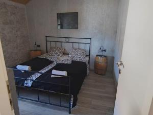 a bedroom with a black bed and a hallway at Vila Kyra in Rtina