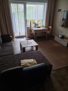 salon z kanapą i stołem w obiekcie Haus Rosi w mieście Friedrichskoog-Spitz