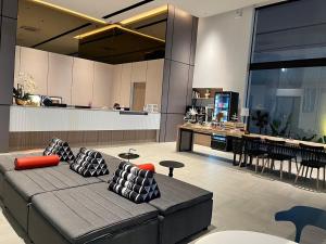 a living room with a couch and a kitchen at Hatyai Midtown Hotel in Hat Yai