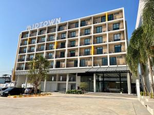 a hotel building with a parking lot in front of it at Hatyai Midtown Hotel in Hat Yai