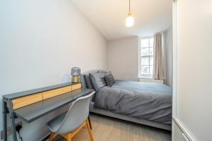 Schlafzimmer mit einem Bett und einem Schreibtisch in der Unterkunft Charming 2 Bedroom Flat in Central London in London
