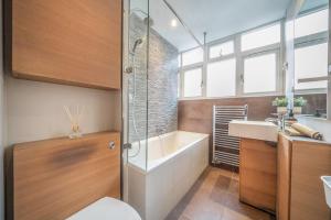 a bathroom with a tub and a sink and a toilet at Charming 2 Bedroom Flat in Central London in London