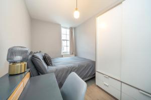 Dormitorio pequeño con cama y espejo en Charming 2 Bedroom Flat in Central London, en Londres