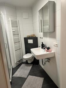 a white bathroom with a sink and a toilet at AMAROOM apartments 2 in Karlsruhe