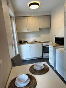 een keuken met witte kasten en witte borden op een tafel bij AMAROOM apartments 2 in Karlsruhe