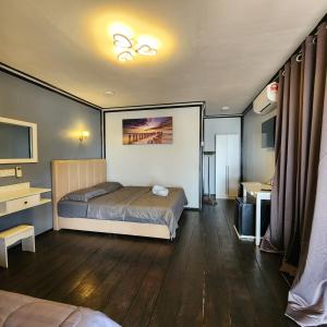 Kampong JuaraにあるPermai Chalet Tiomanのベッドと机とテレビのある寝室