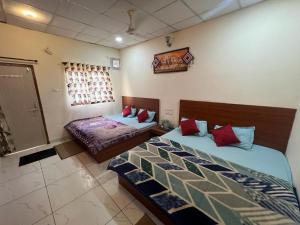 een slaapkamer met 2 bedden en een raam bij Samarth home`stay in Pachmarhī
