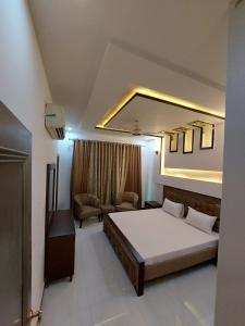 - une chambre avec un grand lit et un canapé dans l'établissement IVY Guest House II, à Islamabad