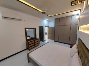 - une chambre avec un lit, un miroir et des armoires dans l'établissement IVY Guest House II, à Islamabad