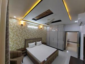 - une chambre avec un lit et un canapé dans l'établissement IVY Guest House II, à Islamabad
