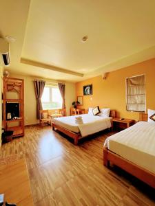 a hotel room with two beds and a television at Lucky Phu Quoc Hotel in Phú Quốc