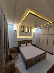 - une chambre avec un grand lit et un miroir dans l'établissement IVY Guest House II, à Islamabad