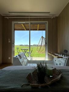 um quarto com uma grande janela com vista para um campo em GreenKub Sauge em Nouaillé-Maupertuis