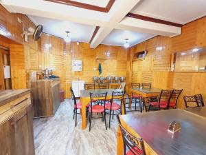 een keuken met houten muren en tafels en stoelen bij HOTEL NEW AASHIYANA in Srinagar
