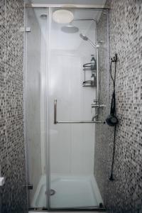 a shower with a glass door in a bathroom at Sunny Hostel Nurmakova in Almaty +31 photos