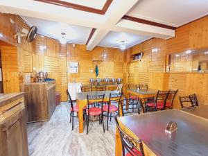 een keuken met houten muren en tafels en stoelen bij HOTEL NEW AASHIYANA in Srinagar