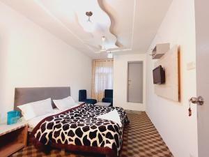 een slaapkamer met een zwart-wit bed en een tv bij HOTEL NEW AASHIYANA in Srinagar