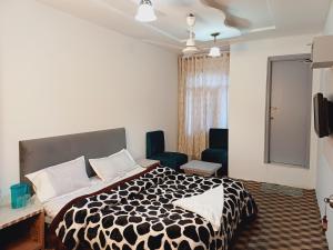 een slaapkamer met een zwart-wit bed en stoelen bij HOTEL NEW AASHIYANA in Srinagar