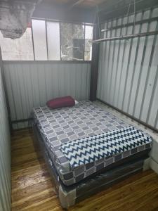 a small bed in a room with a window at Otto’s House in Guatemala