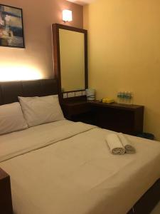 a bedroom with a bed with two towels on it at AVARIA SIGNATURE in Melaka