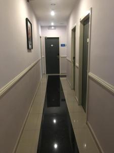 a hallway with a black door and a black floor at AVARIA SIGNATURE in Melaka